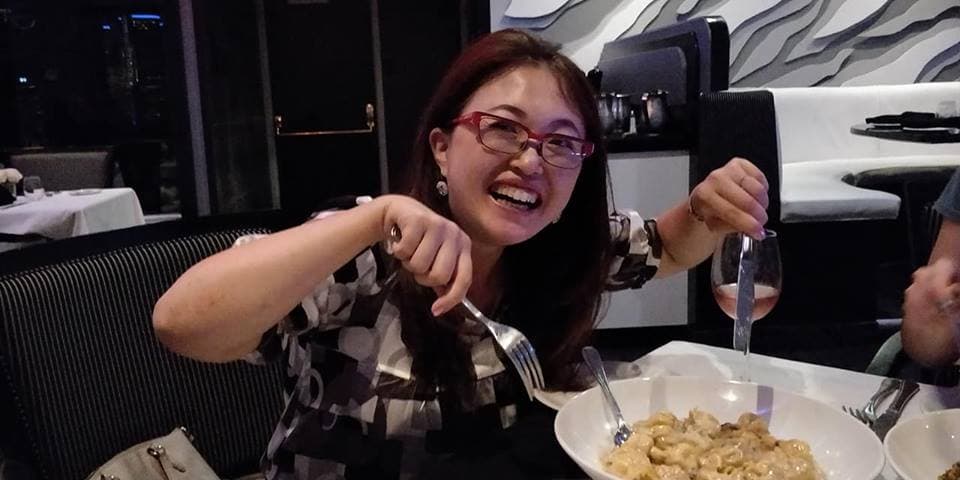 A woman laughing with joy at a beautifully presented meal