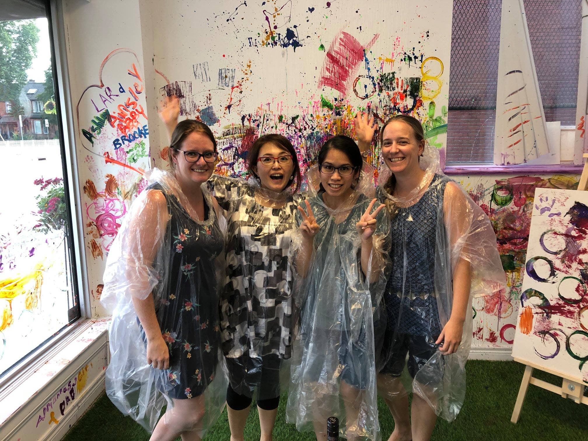 Four women laughing together at a paint night